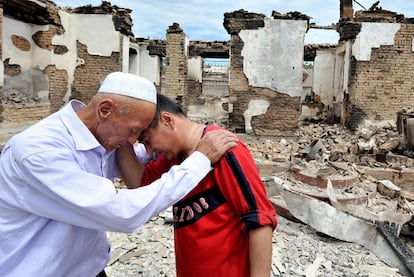 Dos uzbekos se lamentan ante las casas destruidas de la loalidad de Shark, próxima a Osh.