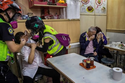 Trabajadores y clientes de un restaurante reciben ayuda tras ser gaseados durante una protesta, el 2 de noviembre de 2019.