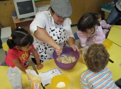La madre de uno de los alumnos de la Casa de Niños de Villaconejos les enseña a preparar roscos.