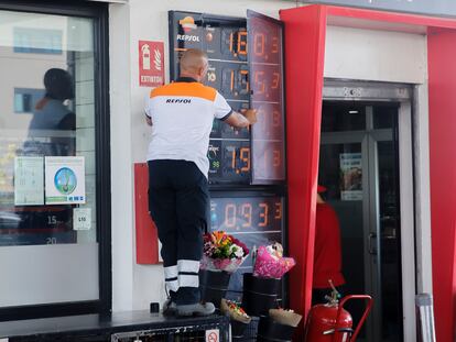 Un trabajador cambia los precios de los carburantes en un panel de una gasolinera de Madrid.