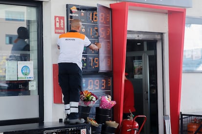 Un trabajador cambia los precios de los carburantes en un panel de una gasolinera de Madrid.