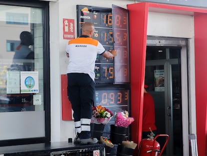 Un trabajador cambia los precios de los carburantes en un panel de una gasolinera de Madrid.