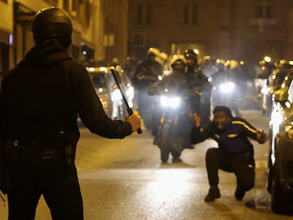 Un hombre reacciona mientras un policía sostiene una porra durante las protestas en París, la pasada madrugada.
