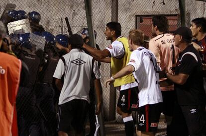 Varios jugadores del Colón gritan a los policías mientras los seguidores del equipo argentino les lanzan piedras.