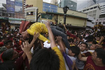 Una persona es ayudada tras sufrir un desmayo durante la procesión del Nazareno Negro por las calles de Manila. Esta procesión se considera uno de los principales eventos religiosos del año de Filipinas.