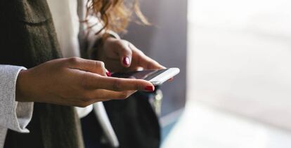 Una mujer usa su teléfono móvil.