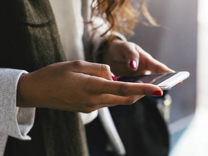 Una mujer usa su teléfono móvil.