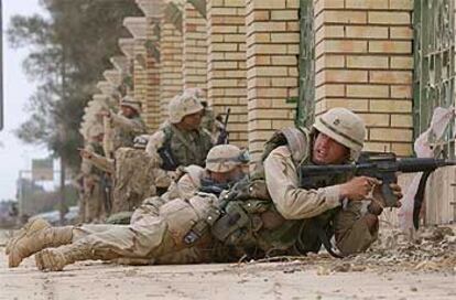 Soldados estadounidenses se ponen a cubierto tras escuchar disparos, el jueves en el centro de Bagdad.