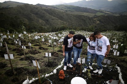 Familiares de Luis Enrique Rodríguez, que murió de covid-19, visitan donde fue enterrado en una colina de la Reserva Natural El Pajonal, al norte de Bogotá, en octubre de 2021. 