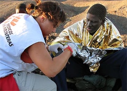 Una enfermera de Médicos sin Fronteras atiende a uno de los 81inmigrantes llegados ayer en tres pateras a Fuerteventura.
