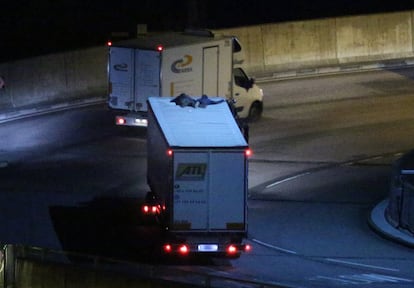 Dos inmigrantes subidos al techo de un camión tratan de cruzar el Eurotunel desde Calais, Francia.