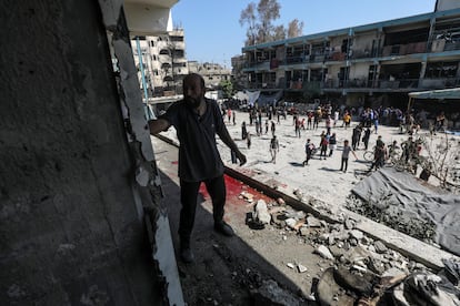 Palestinian citizens observe the damage suffered by the UNRWA school in Nuseirat after the Israeli attack this Thursday.