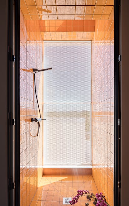 El baño superior cuenta con una ducha interior y otra exterior, con azulejos amarillos, para el verano.