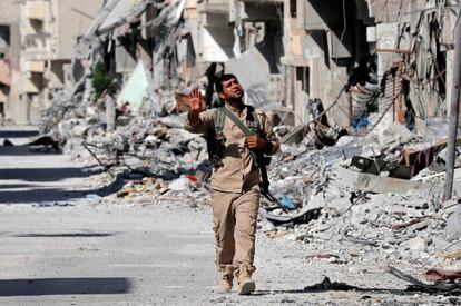 Un soldado de las FDS camina entre edificos destruidos de la ciudad de Raqa, en Siria, el 1 de octubre.