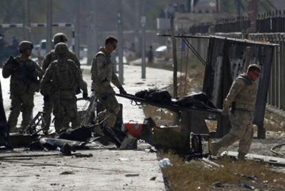 Militares trasladan a un herido en el ataque suicida contra un autobús de la fuerza internacional en Kabul.