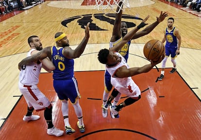 El jugador de los Toronto Raptors Kyle Lowry lanza a canasta ante la oposicion del jugador de Golden State Warriors Draymond Green.