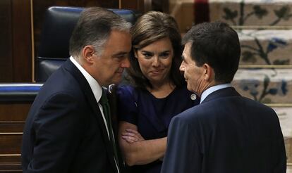 José Enrique Serrano (d), ponente socialista en el pleno de la Ley de Transparencia, conversa con la vicepresidenta del Gobierno, Soraya Sáenz de Santamaría (c) y el diputado popular  Esteban González Pons, en 2013.