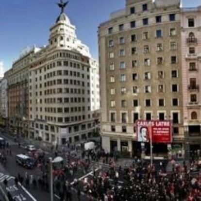 Composición panorámica con varias fotografías de un grupo de manifestantes cortando la Gran Vía de Madrid.