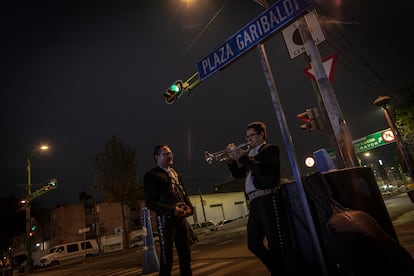 Dos mariachis esperan sobre Eje Central que algún cliente los contrate. 