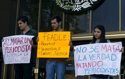 Manifestantes sostienen carteles durante una protesta contra de la violencia hacia los miembros de los medios de comunicación frente a la oficina del Fiscal General en Guadalajara, México en 2017.