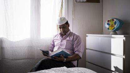 Ansir Hussain reads in his apartment in Barcelona's Sant Antoni neighborhood.