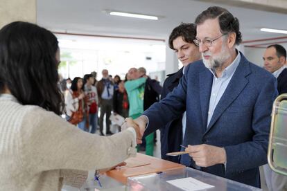 El expresidente del Gobierno Mariano Rajoy, acompañado de su hijo, ejerce su derecho al voto en un centro electoral en Madrid.