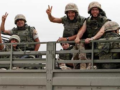 Soldados españoles de la Brigada Plus Ultra II, que volarán hoy a España, hacen la señal de la victoria a su llegada a la frontera de Kuwait.