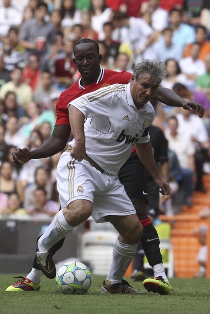 Carlos Alonso 'Santillana' protege el balón ante Dwight Yorke