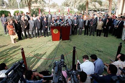 El presidente iraquí, Yalal Talabani (centro), junto a líderes políticos iraquíes en la ceremonia de la firma del borrador de la Constitución, ayer en Bagdad.