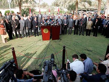 El presidente iraquí, Yalal Talabani (centro), junto a líderes políticos iraquíes en la ceremonia de la firma del borrador de la Constitución, ayer en Bagdad.