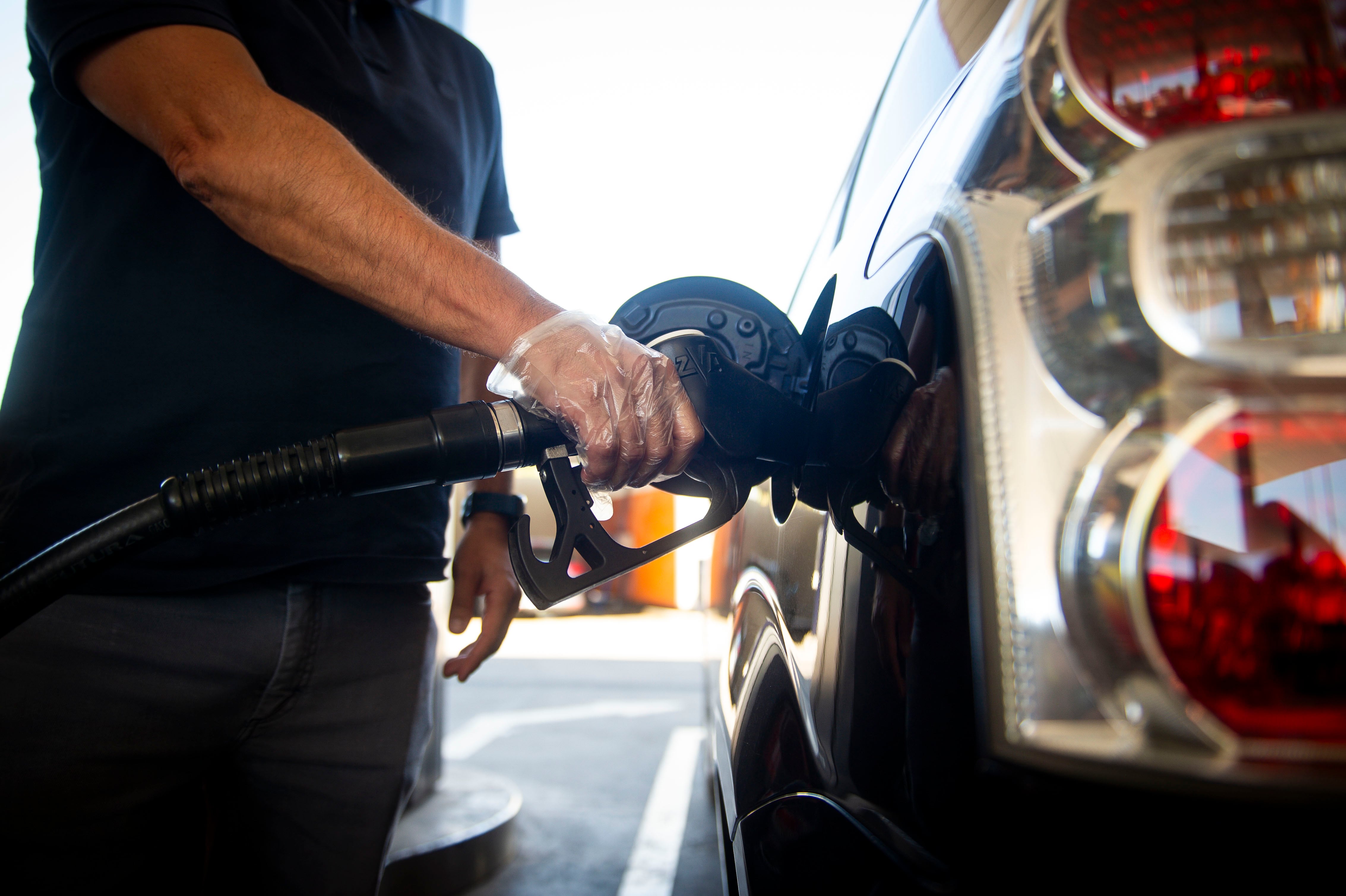 Un conductor reposta gasolina en una estación de servicio Repsol.