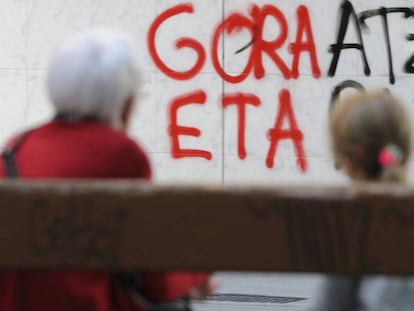 Una mujer y una ni&ntilde;a observan una pintada a favor de ETA en una pared en Vitoria en abril pasado.