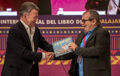 Timochenko, exlíder de la Farc, recibe de Juan Manuel Santos, expresidente de Colombia, un libro infantil para su hijo, tras el encuentro que mantuvieron en la FIL de Guadalajara (México) en 2019. 