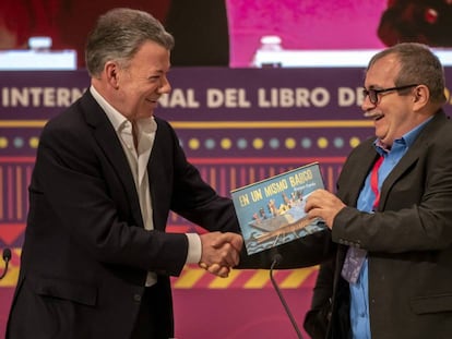 Timochenko recibe de Juan Manuel Santos un libro infantil para su hijo, tras el encuentro que mantuvieron en la FIL. 