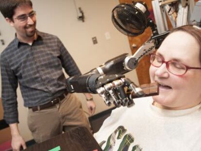 Jan Scheuemann, tetrapléjica debido a una enfermedad neurodegenerativa, se ayuda de un brazo robótico para comer chocolate.