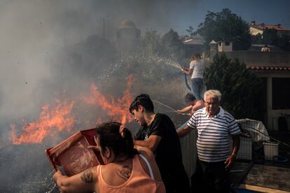Vecinos de Canecas intentan apagar las llamas que rodean sus viviendas. 