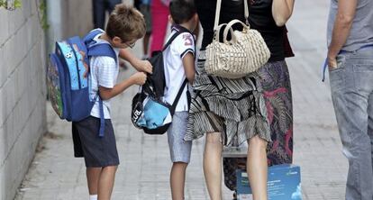 Dos ni&ntilde;os se preparan para entrar al colegio en el primer d&iacute;a del curso escolar 2012/2013.
