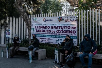 Familiares de enfermos esperan un turno para poder recargar sus tanques de oxígeno en Iztapalapa.