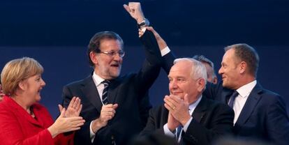 Donald Tusk (d), presidente del Consejo Europeo, levanta el brazo de Rajoy, junto a Joseph Daul, l&iacute;der del PPE, y la canciller alemana Angela Merkel, en el congreso del PP europeo que se celebr&oacute; en el Palacio Municipal de Congresos de Madrid el 23 de octubre de 2015.