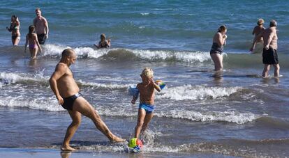 Un hombre juega con un niño en una playa de Gran Canaria. 