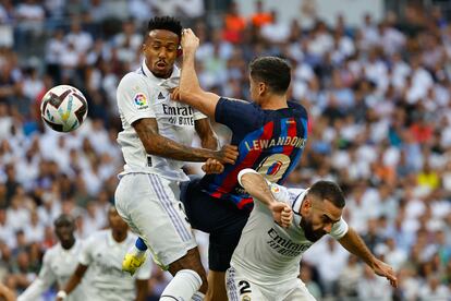 Lewandowski (en el centro) lucha por el balón con Militão (a la izquierda) y Benzema.
