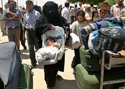 Una mujer y su bebé cruzan el paso de Rafah, entre Egipto y Gaza, junto a otros palestinos que quedaron 19 días atrapados en la frontera.