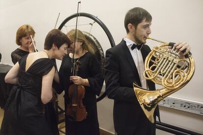 Miembros de la Orquesta Filarmónica de Novosibirsk ensayan en los pasillos antes de un concierto.