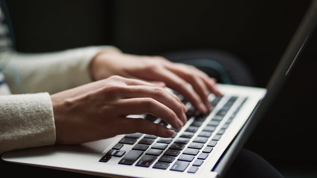 Persona que escribe en el teclado de su portátil.