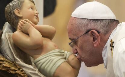 El papa Francisco besa una estatua del niño Jesús, durante la misa de Año nuevo en la basílica del Vaticano.