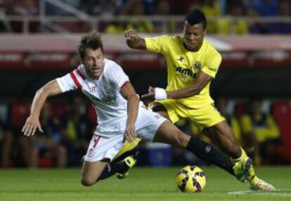 Grzegorz Krychowiak, del Sevilla, recibe una entrada de Ikechukwu Uche, del Villarreal.