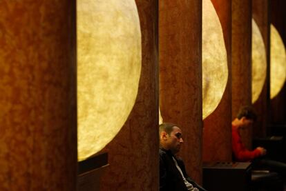 Dos visitantes descansan sentados en unos bancos, en la exposición que el Museo Pushkin de Moscú dedica a Salvador Dalí.