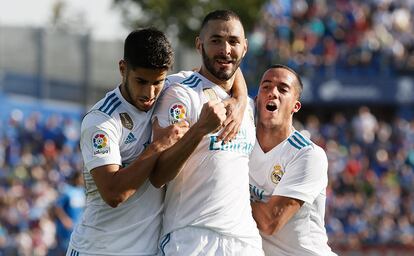 Benzema (c) celebra con sus compañeros Asensio (i) y Lucas Vázquez (d) su gol marcado ante el Getafe.