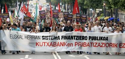 Ainhoa Etxaide y Txiki Muñoz tras la pancarta contra la privatización de Kutxabank