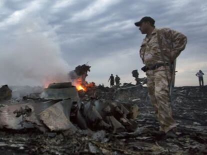 Militares entre los restos del avión derribado en Ucrania.